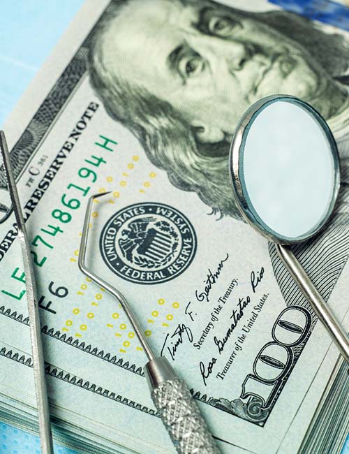 Money and dental tools representing the cost of dental emergencies in Copperas Cove