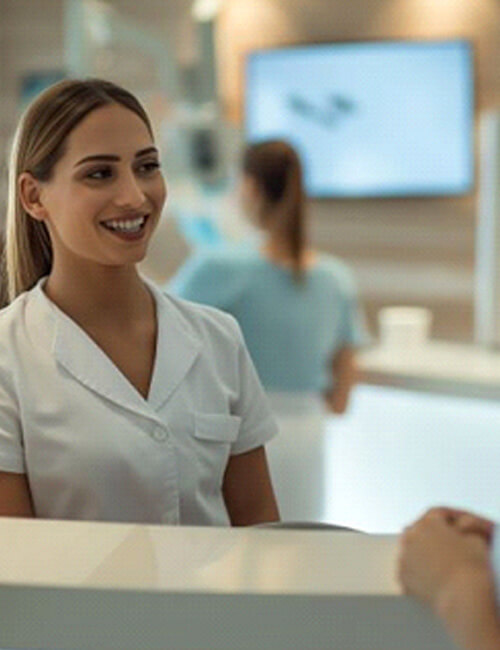 patient and dental team member standing at dental office front desk