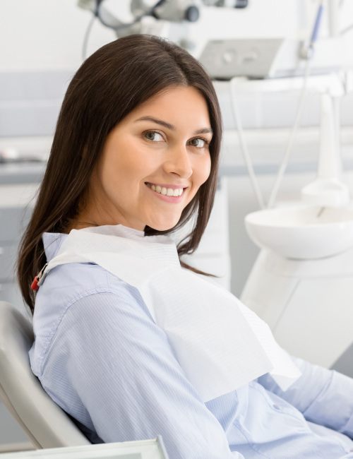 Woman sitting in dental chair and smiling