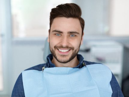 Man sitting in dental chair and smiling