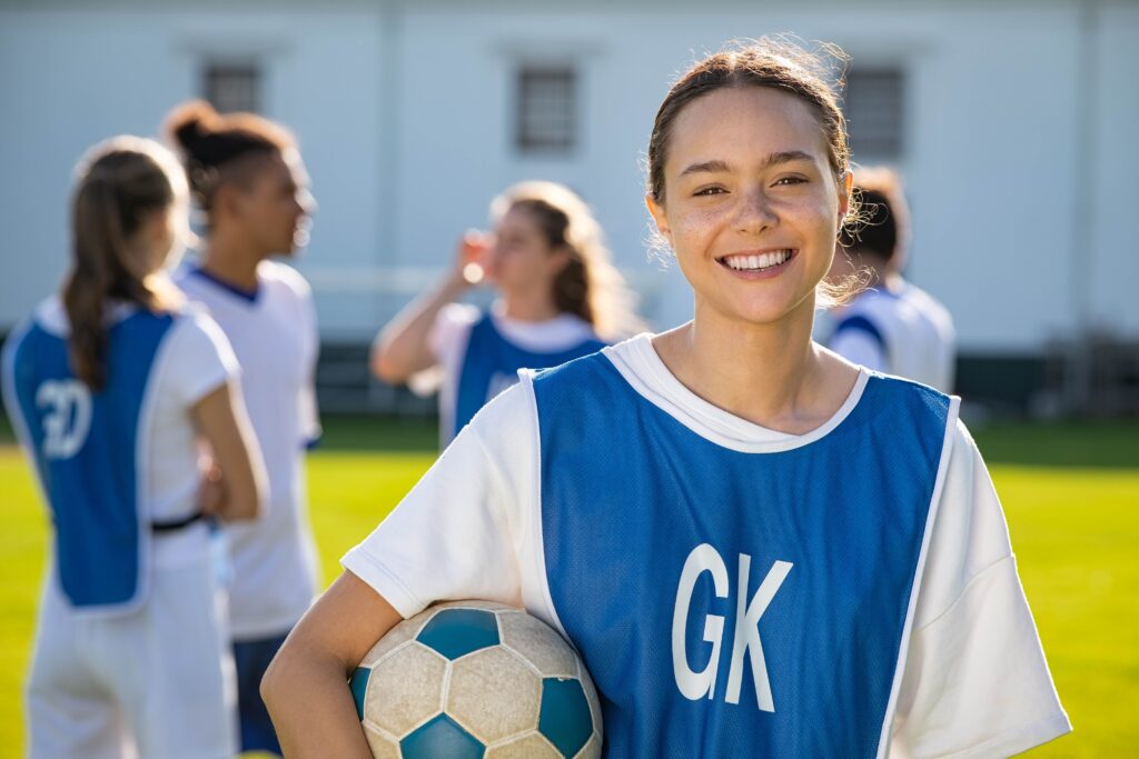 Smiling teen girl holding soccer ball