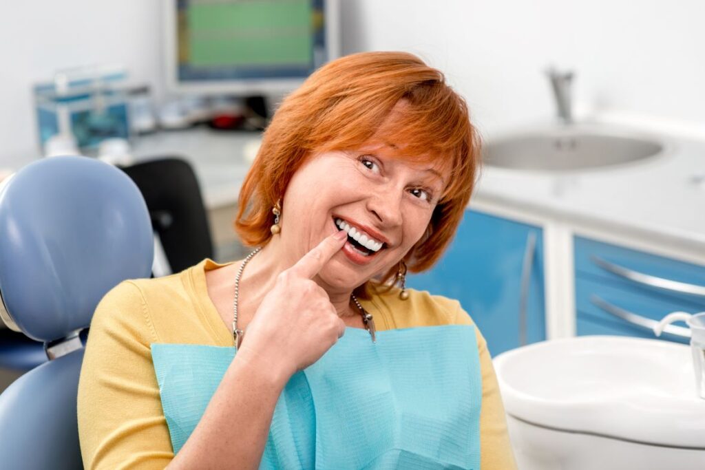 A woman pointing to her dental implant